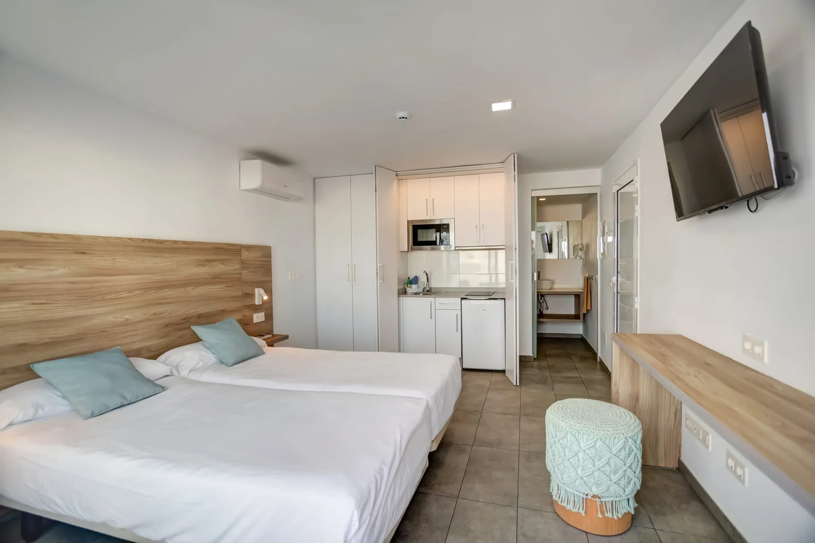 El apartamento entero desde la puerta: dos camas, la cocina y el baño en la misma estancia